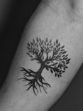 Tatuagem minimalista feita em pontilhismo (dotwork) na região do antebraço, representando a arvore da vida.