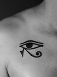 Tatuagem minimalista, somente em preto (blackwork), na região da clavícula, representando o simbolo egipcio "olho de horus".