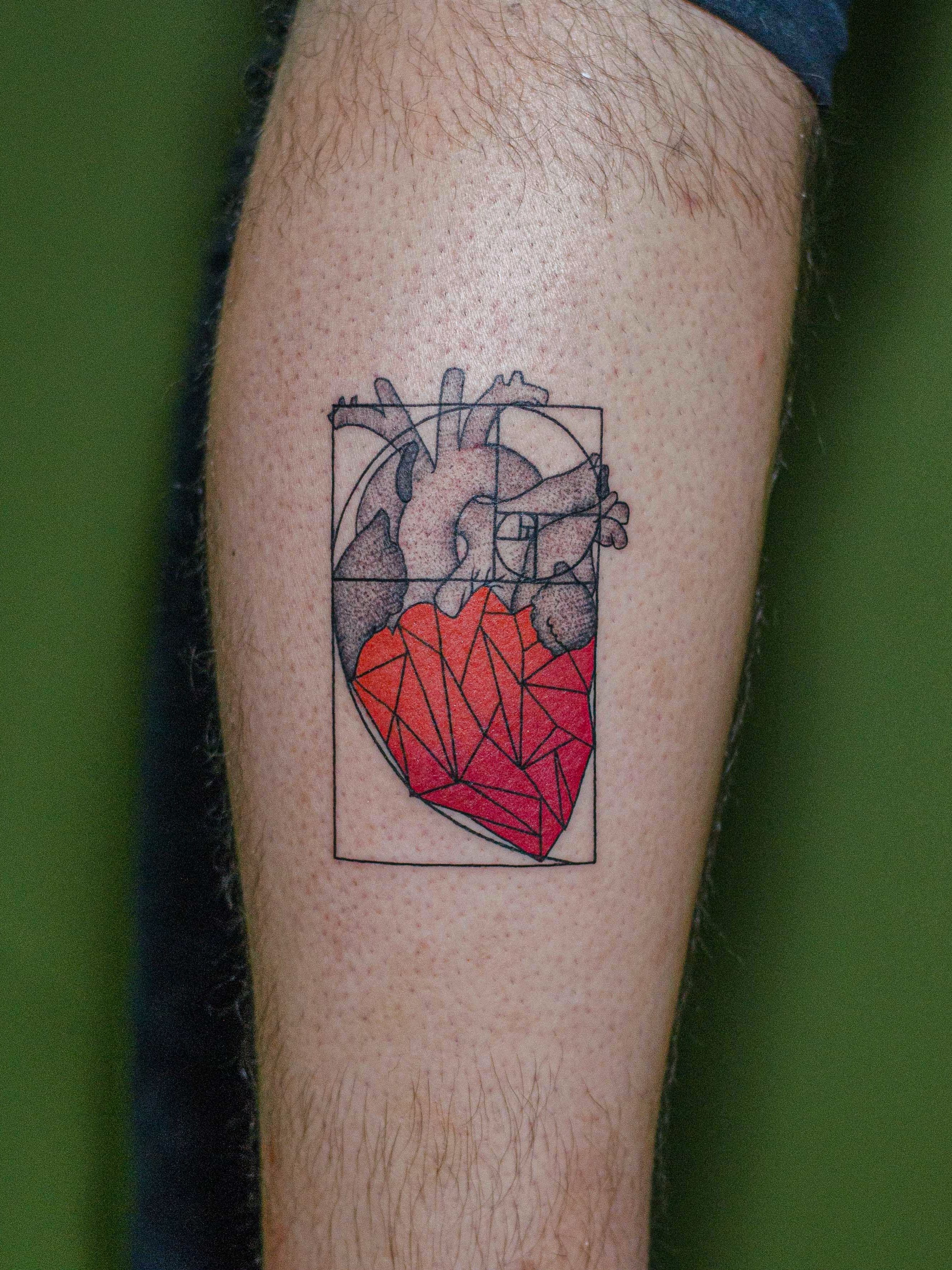Tatuagem minimalista feita em linha fina (fineline), colorida, representando um coração dentro da sequência de fibonacci.