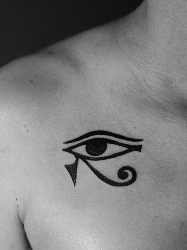 Tatuagem minimalista, somente em preto (blackwork), na região da clavícula, representando o simbolo egipcio "olho de horus".